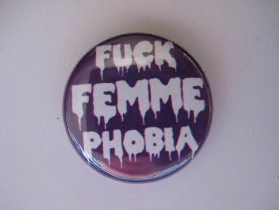 Purple pin with dripping white letters reads “Fuck Femmephobia.”